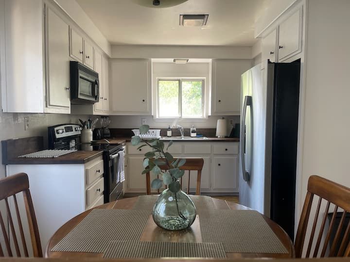 A kitchen with white cabinets and black appliances.