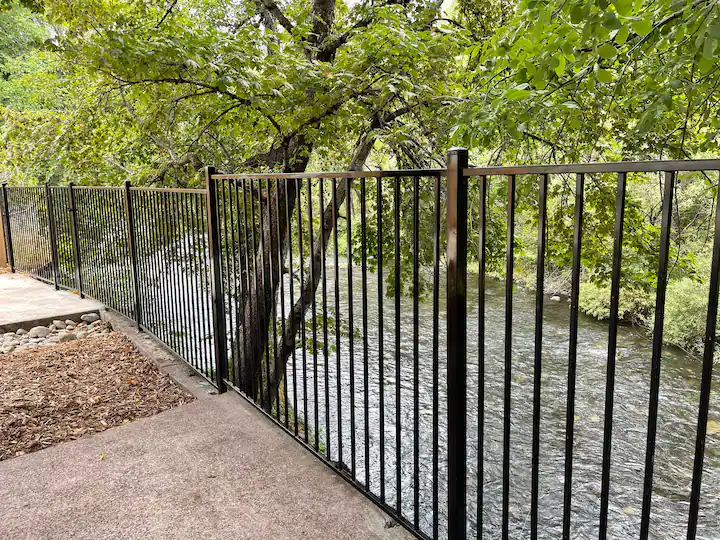 A fence that is next to the water.