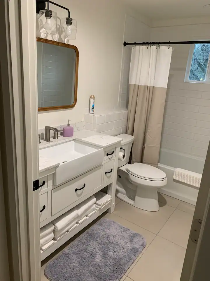 A bathroom with white cabinets and a sink.