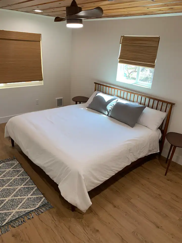 A bed room with a large white bed and two tables