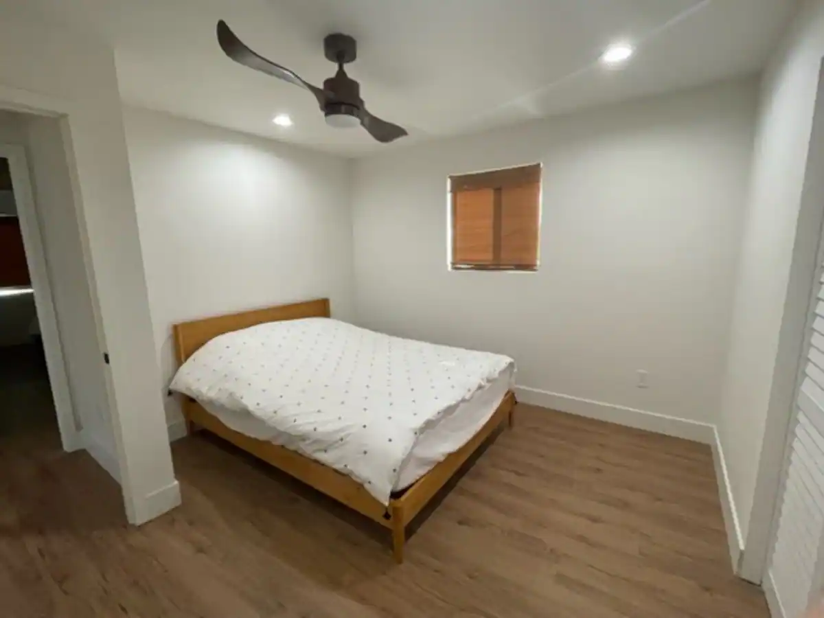 A bedroom with a bed and ceiling fan.