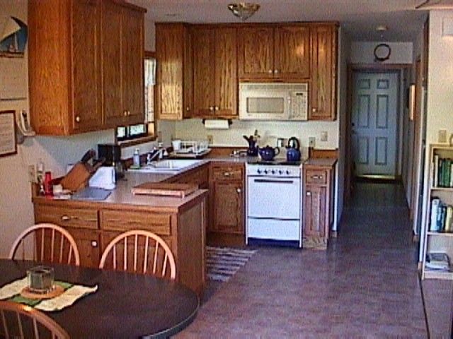 A kitchen with wooden cabinets and white appliances.